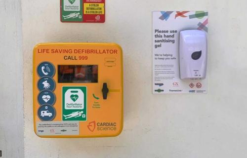 An AED on a wall in an unlocked cabinet